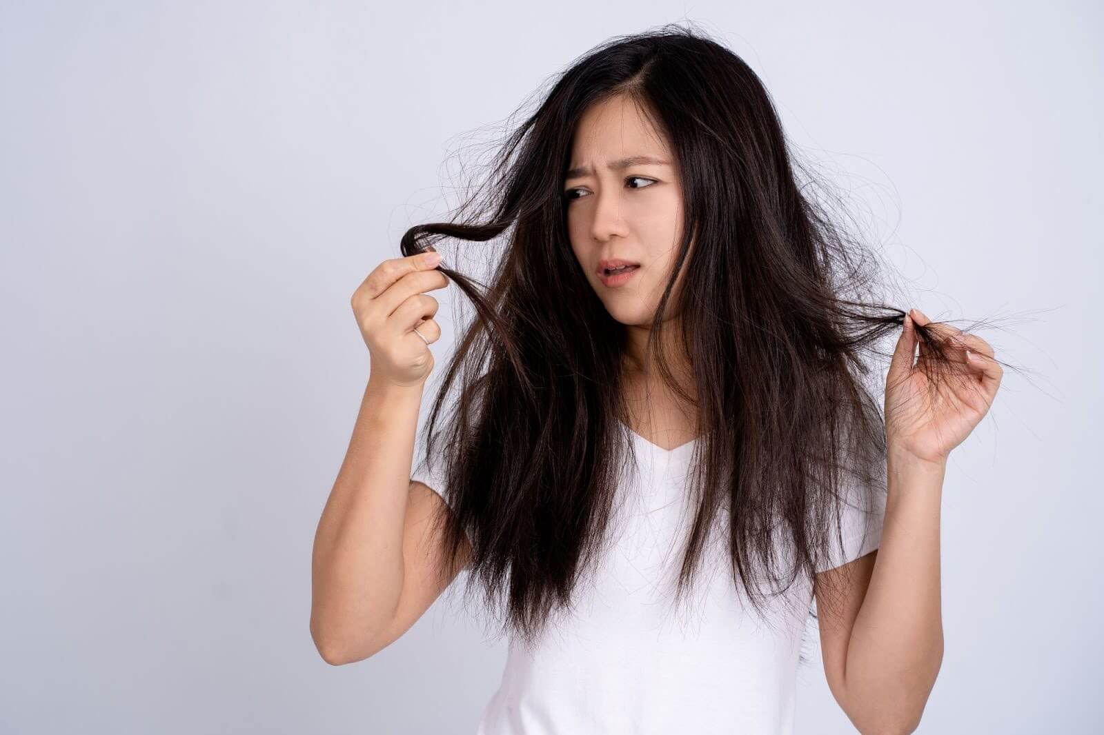 A woman looking at her hair.